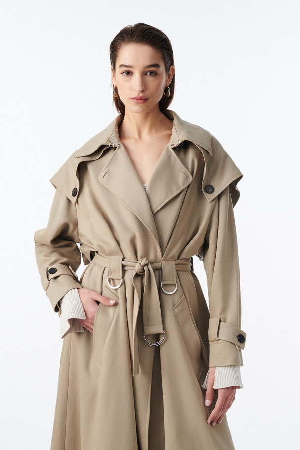 **QARO(카로) 케이프 트렌치 코트**

부드러운 리오셀 소재로 제작되어 봄, 가을에 착용하기 좋은 QARO(카로) 케이프 트렌치 코트입니다. 베이직하고 클래식한 디자인으로, 데이트룩, 오피스룩, 가을 나들이룩 등 다양한 TPO에 활용할 수 있습니다. 롱 기장의 루즈핏으로 편안한 착용감을 선사하며, 허리 벨트와 소매 벨트로 스타일을 연출할 수 있습니다. 무지 디자인에 케이프 타입으로 세련된 포인트를 더했으며, 사이드 포켓이 있어 실용적입니다. 안감은 레이온과 면 혼방으로 제작되었습니다.
