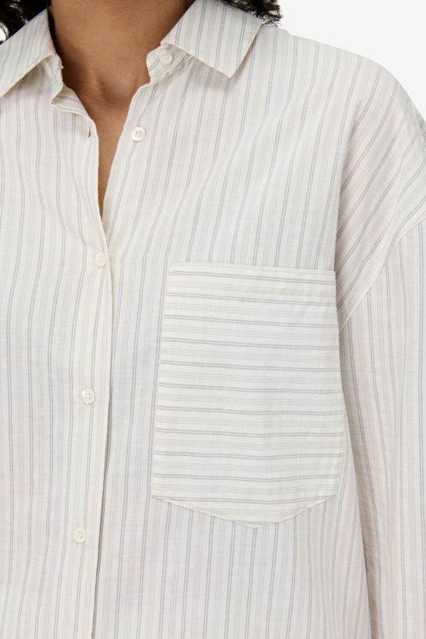 TAMYNA(타미나) 스트라이프 포켓 셔츠는 여성 고객을 위한 캐주얼 스타일의 셔츠/블라우스입니다. 화이트 컬러에 봄, 여름 시즌 착용하기 좋은 얇은 두께의 면 소재로 제작되었습니다. 루즈핏 디자인과 드롭숄더, 싱글 포켓 디테일이 특징이며, 칼라 넥라인과 긴 소매 기장으로 단정함을 더했습니다. 데이트룩, 카페룩, 봄 소풍룩 등 다양한 TPO에 맞춰 미니멀하고 클래식한 스타일을 연출할 수 있습니다. 스트라이프 패턴이 경쾌한 분위기를 선사하여 일상에서 편안하게 착용하기 좋습니다.
