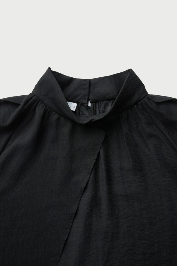 NAHAE(나에) 카울넥 레이어 블라우스는 여성스러운 실루엣을 연출하는 블랙 컬러의 블라우스입니다. 부드러운 레이온, 마, 나일론 혼방 소재로 제작되어 은은한 광택감과 시어한 텍스처, 부드러운 촉감을 선사합니다. 사선 레이어 디자인과 셔링 디테일이 우아하고 클래식한 무드를 더하며, 루즈핏과 긴 소매가 편안한 착용감을 제공합니다. 뒷넥 버튼 여밈으로 깔끔하게 마감되었으며, 카울넥과 하이넥 스타일을 모두 연출할 수 있어 오피스룩, 모임룩, 소개팅룩 등 다양한 TPO에 활용 가능합니다.
