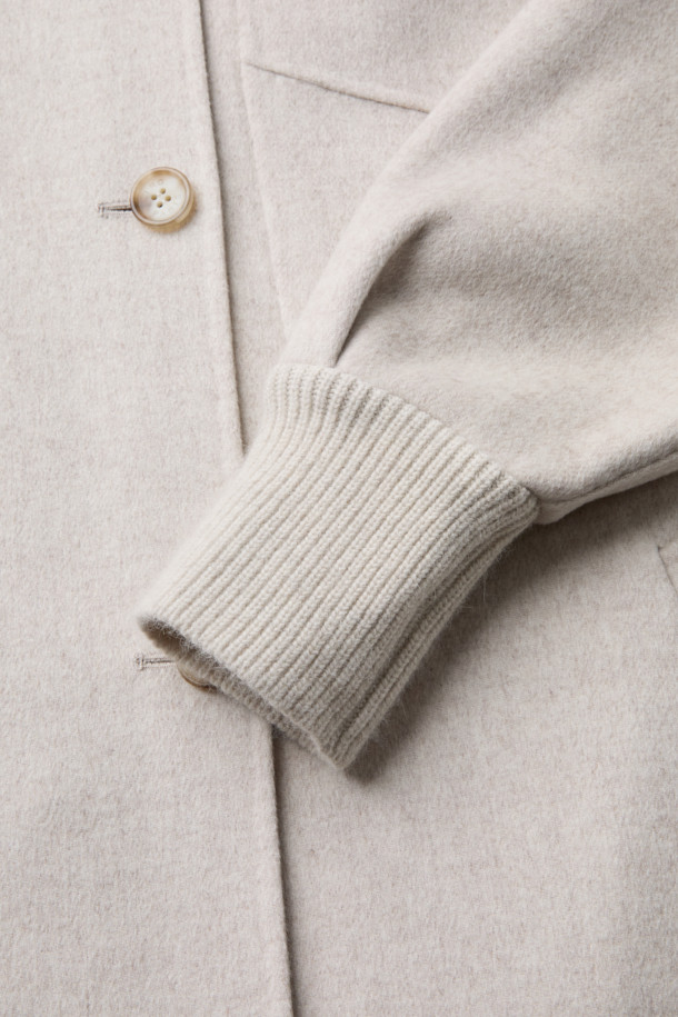 VUIT (뷔) 니트 하이브리드 코트는 부드러운 모 소재로 제작되어 봄 시즌에 적합한 캐주얼 코트입니다. 베이지 색상의 무지 디자인으로 미니멀하고 클래식한 스타일을 연출하며, 드롭 숄더와 니트 밴드 디자인, 사이드 포켓 디테일이 특징입니다. 루즈핏으로 편안한 착용감을 선사하며, 긴 소매 기장과 레이온, 면 안감으로 실용성을 높였습니다. 봄 소풍룩에 완벽하게 어울리는 아이템으로, 다양한 스타일링을 즐길 수 있습니다.
