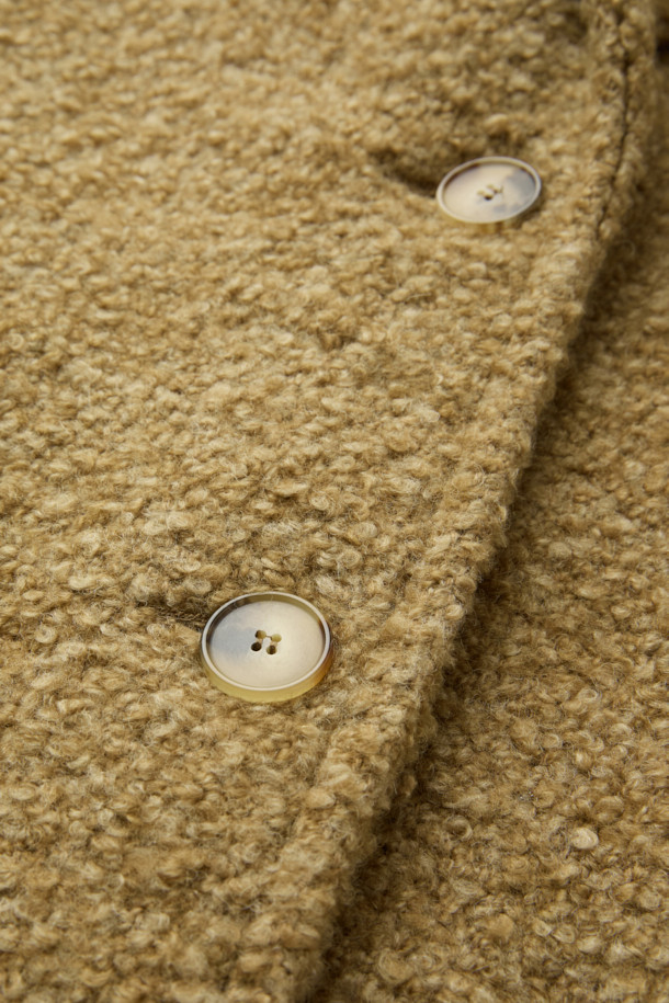 **파리아 숄 카라 부클 코트**는 부드러운 촉감의 모, 폴리에스터, 아크릴 혼방 소재로 제작되어 가을과 겨울에 따뜻하게 착용하기 좋은 두꺼운 두께감의 여성 코트입니다. 베이직하고 클래식한 무드의 브라운 컬러 무지 디자인에 숄 카라 디테일이 돋보이며, 오버핏으로 편안한 착용감을 선사합니다. 싱글 버튼 여밈 방식과 긴 소매 기장, 사이드 포켓 디테일이 특징이며, 안감은 레이온과 면으로 구성되어 있습니다. 출근룩과 모임룩, 클래식 또는 미니멀 스타일을 즐겨 입는 분들께 추천합니다.
