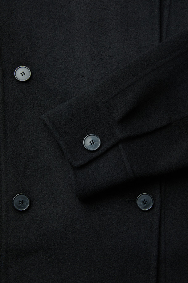 RYNAYA(리나야) 핸드메이드 울 재킷은 가을, 겨울 시즌에 어울리는 여성용 자켓입니다. 미니멀한 스타일의 블랙 컬러 무지 디자인으로, 출근룩, 오피스룩, 모임룩 등 다양한 TPO에 활용하기 좋습니다. 부드러운 울과 나일론 혼방 소재로 제작되어 편안한 촉감을 선사하며, 루즈핏과 크롭 기장으로 세련된 실루엣을 연출합니다. 와이드 라펠과 드롭 숄더, 더블 버튼 여밈, 사이드 포켓 디테일이 특징이며, 안감 처리는 되어 있지 않습니다.
