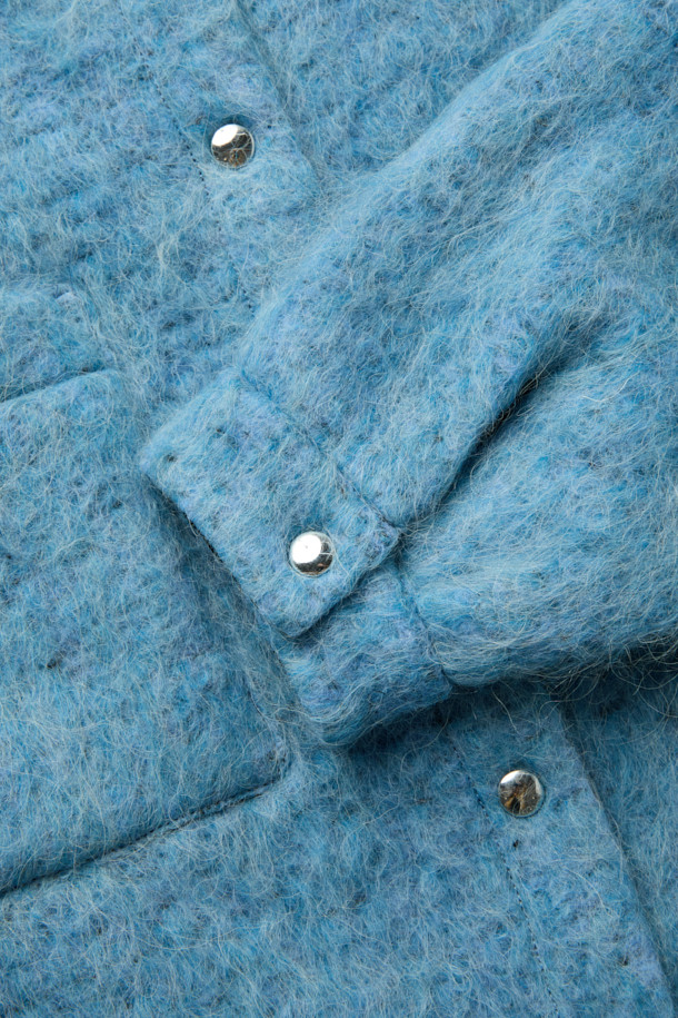 **DOMALSPE(도말스페) 울 셔켓**은 겨울과 가을, 두 계절에 따뜻하게 입을 수 있는 캐주얼 스타일의 셔켓입니다. 부드러운 촉감의 울 부클 소재와 안감(면, 레이온)을 사용하여 편안한 착용감을 선사합니다. 오버핏에 드롭 숄더 디자인으로 트렌디함을 더했으며, 크롭 기장과 오버사이즈 포켓 디테일이 돋보입니다. 스냅 버튼 여밈으로 간편하게 착용 가능하며, 데일리룩, 카페룩, 산책룩 등 다양한 TPO에 활용하기 좋습니다. 톤 다운된 블루 컬러의 무지 디자인으로 미니멀, 클래식 스타일을 즐기는 분들께 추천합니다.
