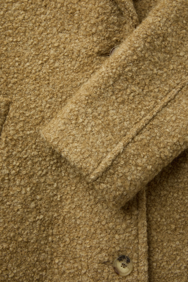 **파리아 숄 카라 부클 코트**는 부드러운 촉감의 모, 폴리에스터, 아크릴 혼방 소재로 제작되어 가을과 겨울에 따뜻하게 착용하기 좋은 두꺼운 두께감의 여성 코트입니다. 베이직하고 클래식한 무드의 브라운 컬러 무지 디자인에 숄 카라 디테일이 돋보이며, 오버핏으로 편안한 착용감을 선사합니다. 싱글 버튼 여밈 방식과 긴 소매 기장, 사이드 포켓 디테일이 특징이며, 안감은 레이온과 면으로 구성되어 있습니다. 출근룩과 모임룩, 클래식 또는 미니멀 스타일을 즐겨 입는 분들께 추천합니다.
