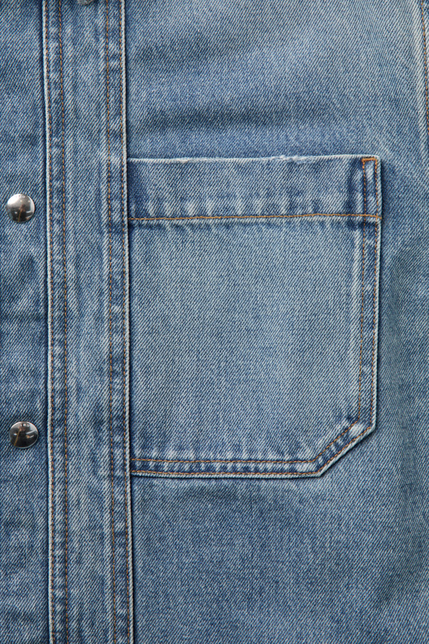 시도니 데님 셔츠는 봄, 가을에 어울리는 캐주얼 스타일의 데님 자켓입니다. 블루 컬러의 무지 디자인으로, 오버핏 크롭 기장과 긴 소매가 특징입니다. 스냅 버튼으로 여밈이 가능하며, 포켓과 패널 스티치 디테일이 돋보입니다. 봄 소풍룩이나 미니멀한 스타일 연출에 적합한 아이템입니다.
