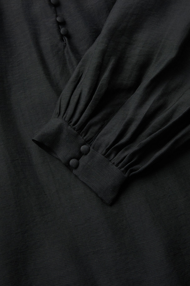 NAHAE(나에) 카울넥 레이어 블라우스는 여성스러운 실루엣을 연출하는 블랙 컬러의 블라우스입니다. 부드러운 레이온, 마, 나일론 혼방 소재로 제작되어 은은한 광택감과 시어한 텍스처, 부드러운 촉감을 선사합니다. 사선 레이어 디자인과 셔링 디테일이 우아하고 클래식한 무드를 더하며, 루즈핏과 긴 소매가 편안한 착용감을 제공합니다. 뒷넥 버튼 여밈으로 깔끔하게 마감되었으며, 카울넥과 하이넥 스타일을 모두 연출할 수 있어 오피스룩, 모임룩, 소개팅룩 등 다양한 TPO에 활용 가능합니다.
