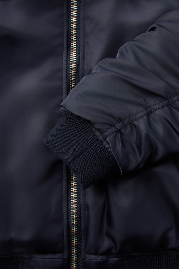 JOLINE(졸린) 퍼 카라 사틴 봄버 재킷은 부드러운 촉감의 폴리에스터, 나일론 혼방 소재로 제작되어 봄 시즌에 적합한 두께감을 제공합니다. 네이비 색상의 무지 디자인에 숏 기장으로, 캐주얼하고 미니멀한 스타일을 연출합니다. 지퍼형 여밈 방식과 레귤러핏 디자인으로 편안한 착용감을 선사하며, 퍼 카라, 사이드 포켓, 소매 및 밑단 립 디테일이 특징입니다. 광택감 있는 소재와 긴 소매, 충전재, 폴리에스터 안감으로 보온성을 더한 항공 점퍼 스타일의 재킷입니다.
