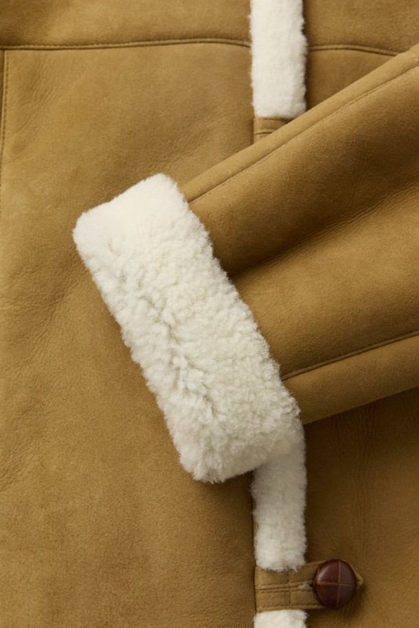 HUESCA(후에스카) 시어링 후드 재킷은 부드러운 스웨이드와 천연 가죽 소재에 시어링 안감으로 포근함을 더한 여성용 아우터입니다. 브라운과 화이트 두 가지 컬러로 출시되었으며, 캐주얼, 클래식, 미니멀 스타일을 모두 아우르는 디자인입니다. 크롭 기장에 레귤러 핏으로 제작되어 다리가 길어 보이는 효과를 주며, 버튼 여밈 방식과 긴 소매, 시어링 디테일 및 사이드 포켓이 특징입니다. 데이트룩과 모임룩에 활용하기 좋으며, 겨울철 따뜻함과 스타일을 동시에 잡을 수 있는 아이템입니다.
