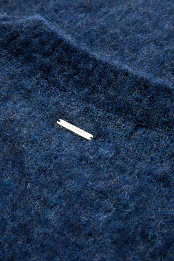 **Auras(오라스) 헤어리 니트 풀오버**는 부드러운 촉감과 따뜻함을 선사하는 겨울철 필수 아이템입니다. 오버핏 라운드넥 디자인으로 편안한 착용감을 제공하며, 헤어리한 표면감이 특징입니다. 아크릴, 알파카, 나일론, 모 소재 혼방으로 제작되어 보온성을 높였습니다. 네이비 컬러의 베이직 스타일로 집콕룩, 산책룩 등 다양한 TPO에 활용 가능하며, 클래식, 미니멀, 캐주얼 스타일을 연출하기 좋습니다. 두꺼운 두께감과 긴 소매 기장으로 겨울철에도 따뜻하게 입을 수 있습니다.
