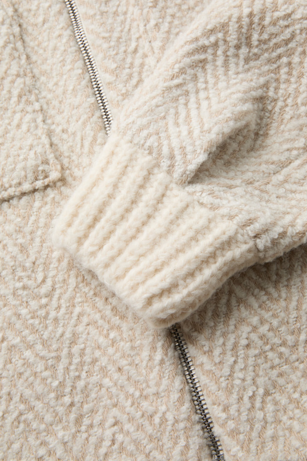 SANOBSPE 니트 하이브리드 ZIP-UP 재킷은 가을, 겨울 시즌을 위한 공용 아우터입니다. 아이보리, 베이지 두 가지 색상으로 출시되었으며, 헤링본 패턴에 부드러운 촉감의 울, 알파카, 아크릴, 폴리에스터, 나일론, 레이온 혼방 소재를 사용하여 보온성을 높였습니다. 세미 오버핏에 레귤러 기장으로 제작되었으며, 2WAY 지퍼 디테일로 실용성을 더했습니다. 출근룩, 모임룩 등 다양한 TPO에 클래식하고 미니멀한 스타일을 연출할 수 있습니다.
