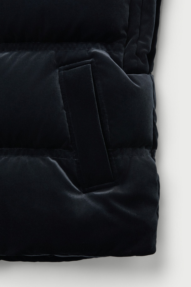 블랙 컬러의 'VELVET' 베스트입니다. 부드러운 촉감의 폴리에스터, 폴리우레탄 혼방 소재로 제작되어 가을, 겨울 시즌에 따뜻하게 착용할 수 있습니다. 두꺼운 두께감과 오버핏 디자인으로 캐주얼하고 미니멀한 스타일을 연출하며, 캠핑룩에도 잘 어울립니다. 집업 여밈 방식에 민소매 디자인, 드롭 숄더, 사이드 포켓과 스토퍼 조임 디테일이 특징입니다. 안감은 폴리에스터로 마감되었습니다.

