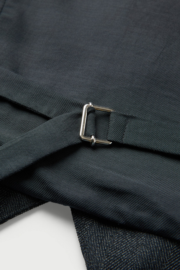 BENYO 웨이스트코트 베스트 탑은 봄, 가을 시즌에 어울리는 클래식하고 포멀한 스타일의 웨이스트코트입니다. 블랙 컬러의 무지 디자인으로, 오피스룩, 비즈니스 캐주얼, 모임룩 등 다양한 TPO에 활용 가능합니다. 앞면은 울 혼방 소재, 뒷면은 레이온 배색으로 제작되었으며, 레귤러핏 V넥 민소매 디자인으로 시크하고 미니멀한 무드를 연출합니다. 버튼업 디자인과 셋업 가능한 특징이 있으며, 안감은 레이온 소재를 사용했습니다.
