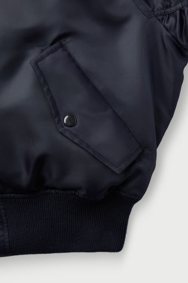 JOLINE(졸린) 퍼 카라 사틴 봄버 재킷은 부드러운 촉감의 폴리에스터, 나일론 혼방 소재로 제작되어 봄 시즌에 적합한 두께감을 제공합니다. 네이비 색상의 무지 디자인에 숏 기장으로, 캐주얼하고 미니멀한 스타일을 연출합니다. 지퍼형 여밈 방식과 레귤러핏 디자인으로 편안한 착용감을 선사하며, 퍼 카라, 사이드 포켓, 소매 및 밑단 립 디테일이 특징입니다. 광택감 있는 소재와 긴 소매, 충전재, 폴리에스터 안감으로 보온성을 더한 항공 점퍼 스타일의 재킷입니다.
