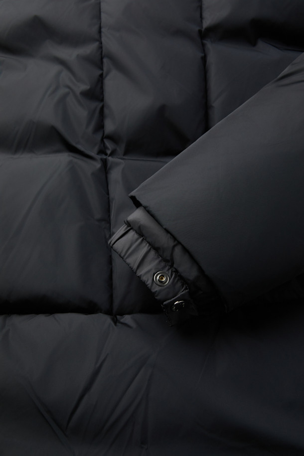 미니멀하고 테크니컬한 디자인의 후드 테크니컬 구스다운 점퍼입니다. 겨울철 출근룩과 여행룩에 적합하며, 오버핏으로 편안한 착용감을 선사합니다. 90/10 구스다운 충전재로 뛰어난 보온성을 제공하며, 탈부착 넥워머와 소매 바람막이 디테일이 추위를 효과적으로 막아줍니다. 가볍고 따뜻한 일상용 아우터로, 무지 디자인과 블랙 컬러로 어떤 스타일에도 쉽게 매치할 수 있습니다. 겉감은 나일론, 안감은 폴리에스터를 사용하여 내구성을 높였습니다.
