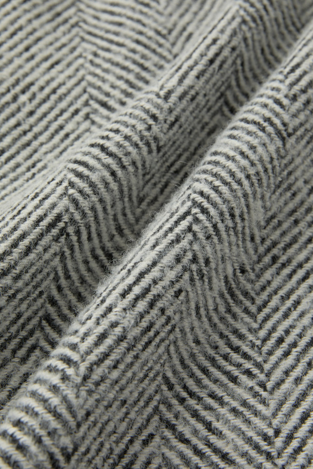 "CLAUDE(클로드) 오버핏 헤링본 코트는 가을, 겨울 시즌을 위한 아우터입니다. 모, 폴리에스터, 나일론 혼방 소재로 제작되어 두꺼운 두께감과 긴 소매 기장이 특징이며, 안감은 레이온으로 마감되었습니다. 그레이 컬러의 헤링본 패턴에 싱글코트 디자인으로, 버튼 여밈 방식의 롱 기장 오버핏 코트입니다. 클래식하고 미니멀하며 시크한 스타일로, 출근룩, 오피스룩, 모임룩 등 다양한 TPO에 활용 가능합니다. 라이선스 코트 핏으로 제작되어 세련된 실루엣을 연출합니다."
