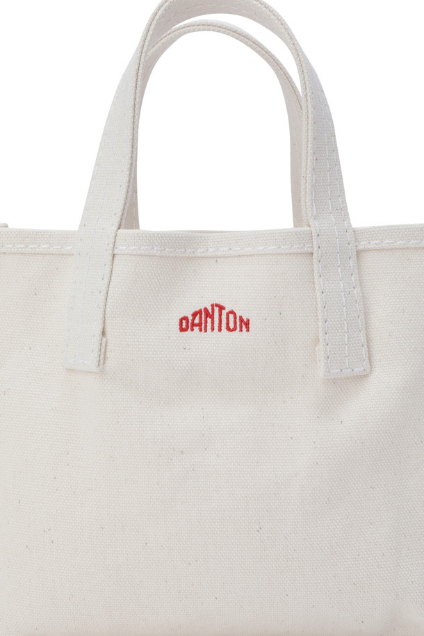 (DANTON) 캔버스 토트백 - 보쥬 쁘띠 에크루(레드)는 18온스 캔버스 소재로 제작되어 튼튼함을 자랑하는 여성용 토트백입니다. 에크루와 레드의 조화가 돋보이며, 사각 모양에 화이트 스티치 디테일이 더해져 미니멀하고 클래식한 스타일을 연출합니다. 가방 전면에 로고 자수 디테일이 포인트로 들어가 있으며, 오픈형 디자인으로 내부 수납이 용이합니다. 데이트룩이나 쇼핑룩에 잘 어울리는 미디엄 사이즈의 무지 토트백으로, 내부 포켓은 없습니다.
