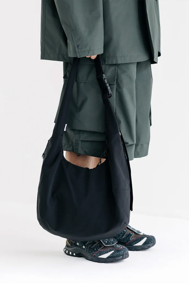 (CLESSTE) 소프트 쉘 시스템 어드저스터 백 - 블랙은 미니멀, 캐주얼, 시크 스타일을 추구하는 남성 고객을 위한 가방입니다. 부드러운 나일론 소재의 반원 형태 크로스백으로, 블랙 색상에 버클 디테일로 포인트를 주었습니다. 가방 내부에는 넉넉한 수납공간이 마련되어 있으며, 스트랩 조절을 통해 편리하게 사이즈를 조절할 수 있습니다. 일상생활에서 다양한 소지품을 안전하고 스타일리시하게 휴대할 수 있는 실용적인 아이템입니다.
