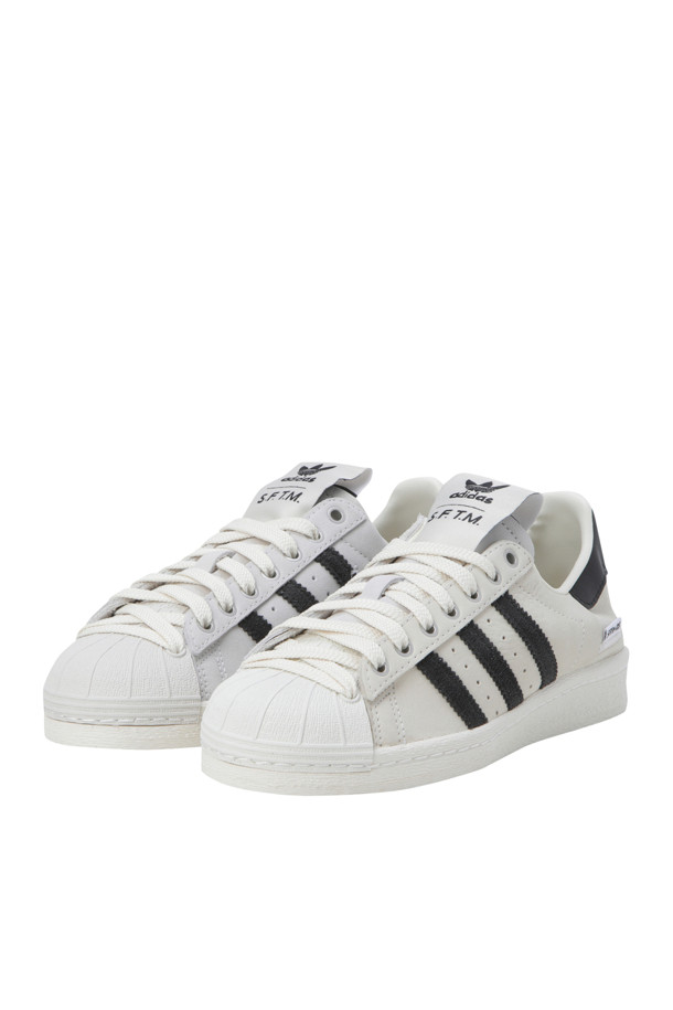 (아디다스 X 송 포 더 뮤트) 슈퍼스타 82 - 크림 화이트 / 코어 블랙 / 오프 화이트는 남성용 운동화입니다. 크림 화이트, 코어 블랙, 오프 화이트 색상 조합의 무지 디자인으로, 사계절 내내 일상용으로 착용하기 좋습니다. 쉘 토 앞코와 레이스업 잠금장치가 특징이며, 가죽, 스웨이드, 고무 소재로 제작되었습니다. 스웨이드 색조와 대조적인 톤의 갑피 패널, 시그니처 슈퍼스타 토 쉘, 추가 레이스 아이릿 디테일이 돋보이며, 미니멀, 클래식, 캐주얼 스타일을 연출하기에 적합합니다. 동네 마실룩이나 데이트룩에 포인트를 더해보세요.