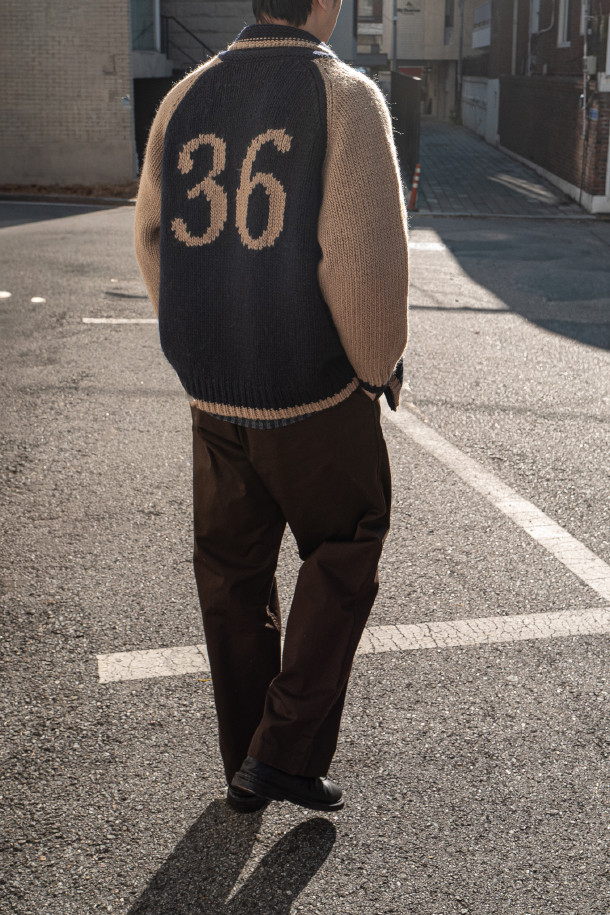 **HEAVY WOOL Cardigan 헤비 울 가디건 - Navy/Camel**

클래식과 빈티지 무드를 아우르는 헤비 울 가디건입니다. 두꺼운 두께감의 울 소재로 제작되어 겨울철에도 뛰어난 보온성을 제공하며, 거친 촉감이 특징입니다. 네이비와 카멜 두 가지 컬러로 출시되었으며, 잦은 착용에도 변형 없이 튼튼하게 유지됩니다. 코위찬 니트에서 영감을 받은 디자인에 빈티지 베이스볼 재킷의 모티브를 더했으며, YKK Excella 지퍼를 사용하여 고급스러움을 더했습니다. 출근룩, 캐주얼룩, 미니멀룩 등 다양한 스타일에 활용하기 좋습니다.
