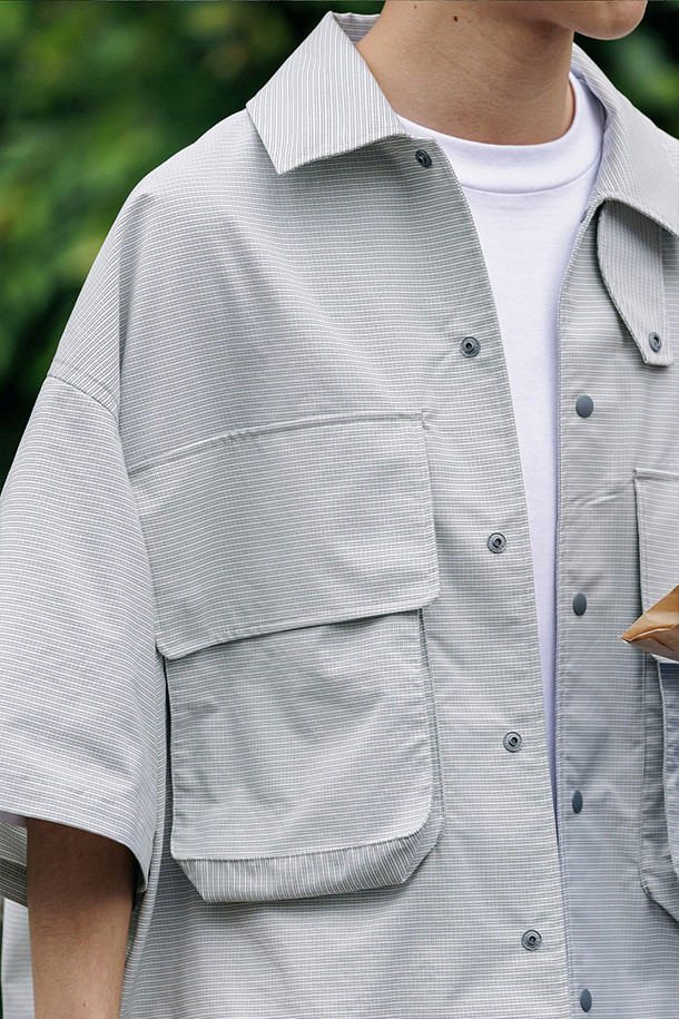 (CLESSTE) GRAPH CHECK WADING S/S 셔츠 재킷 - 화이트 X 블랙은 캐주얼, 스포티, 미니멀 스타일을 아우르는 남성용 셔츠형 자켓입니다. 봄, 여름 시즌에 적합하며, 체크 패턴과 화이트, 블랙 컬러 배색이 특징입니다. 반소매 기장과 얇은 두께감으로 시원하게 착용 가능하며, 스탠드업 칼라와 드로우스트링, 플랩 포켓 디테일이 돋보입니다. 레귤러핏으로 제작되어 편안한 착용감을 제공하며, 여행룩과 휴가룩에 잘 어울립니다. 버튼 여밈 방식으로 간편하게 스타일링할 수 있는 크롭 기장의 셔츠 자켓입니다.
