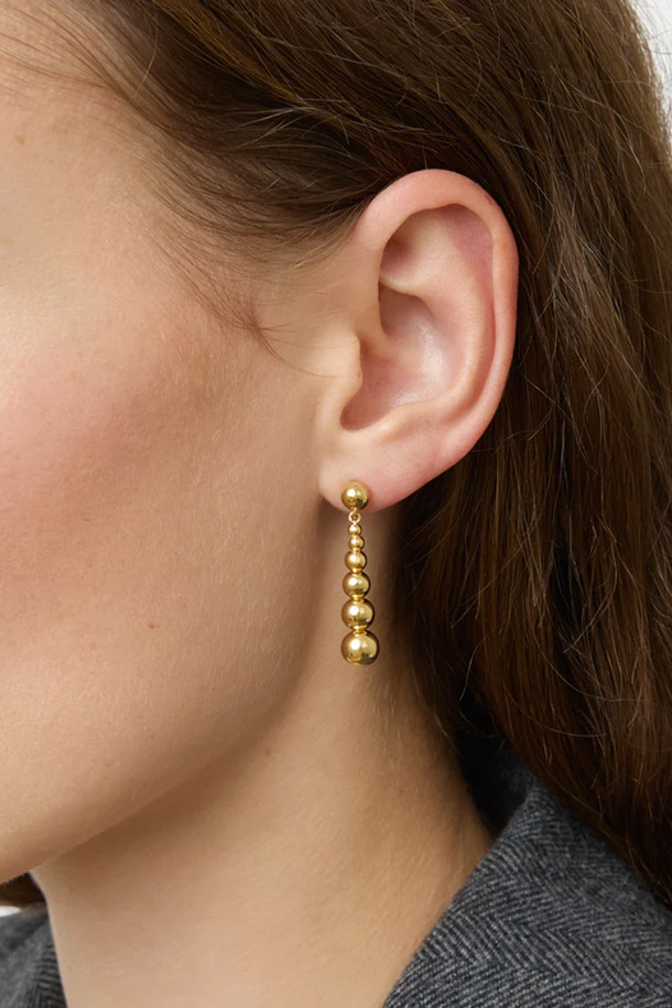 LIE STUDIO(리 스튜디오)의 THE REBECCA EARRINGS - GOLD(더 레베카 이어링스 - 골드)는 미니멀한 스타일을 추구하는 여성들을 위한 드롭 스타일 귀걸이입니다. 18K 골드 도금된 스털링 실버 소재에 노르딕 디자인과 수공예 비즈 디테일을 더해 고급스러움을 더했습니다. 알레르기 걱정 없이 착용 가능한 하이포알러제닉 기능으로 제작되어 편안함을 제공합니다. 데이트룩, 모임룩 등 특별한 날, 혹은 클래식, 시크한 스타일을 연출하고 싶은 날에 매치하여 세련된 분위기를 연출해보세요. 4.7g의 가벼운 무게로 편안하게 착용 가능하며, 물, 향수, 땀에 닿지 않도록 주의하여 파우치나 케이스에 보관해주세요.
