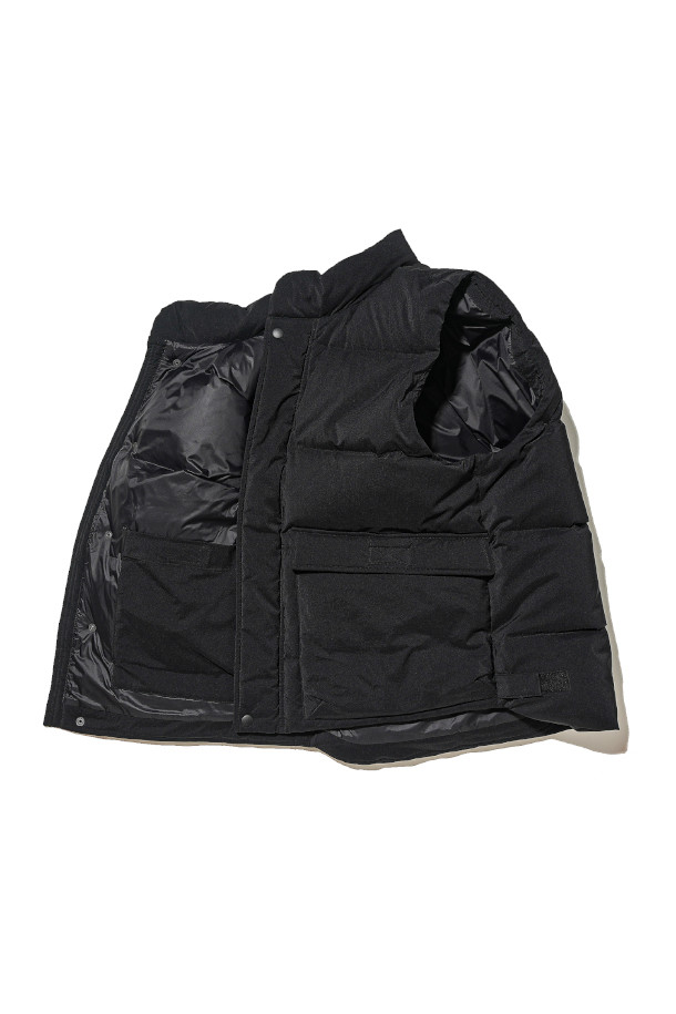 DUCK DOWN MARK 베스트 - 블랙은 겨울철 일상룩, 여행룩, 산책룩에 모두 잘 어울리는 아우터입니다. 영국군 바디 아머를 모티브로 한 밀리터리 스타일의 레귤러핏 베스트로, 유러피안 덕다운 충전재를 사용하여 뛰어난 보온성을 자랑합니다. 

두꺼운 두께감과 부드러운 촉감, 그리고 발수 기능까지 갖춰 한겨울에도 쾌적하게 착용할 수 있습니다. 블랙 컬러의 무지 디자인으로 클래식, 미니멀, 캐주얼 등 다양한 스타일링에 활용하기 좋으며, 레이어링이 용이하여 실용성을 더합니다. 
