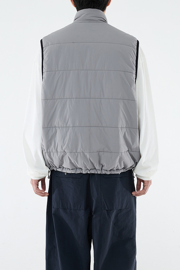 **REVERSIBLE PUFF VEST - CLOUD GRAY/NAVY (리버서블 패딩 베스트 - 클라우드 그레이/네이비)**

클라우드 그레이와 네이비 컬러 양면으로 착용 가능한 남성용 리버서블 패딩 베스트입니다. 가을, 겨울 시즌에 적합하며, 캐주얼 및 스포티 스타일을 연출할 수 있습니다. 넉넉한 루즈핏으로 편안한 착용감을 제공하며, 지퍼형 여밈과 스탠드 카라 디자인으로 보온성을 높였습니다. 방수, 보온, 통기 기능에 신슐레이트 충전재를 사용하여 한겨울에도 따뜻하게 입을 수 있습니다. 일상, 산책, 여행 등 다양한 TPO에 활용하기 좋은 아이템입니다.

