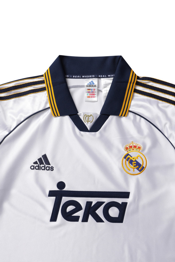 레알 마드리드 99/00 홈 유니폼 - 화이트는 남성용 스포츠 의류입니다. 봄, 여름 시즌에 적합하며, 스포티하고 클래식한 스타일을 연출합니다. 헨리넥 디자인에 루즈핏으로 편안하게 착용 가능하며, 반소매 기장과 로고 패턴이 특징입니다. 레트로 축구 유니폼으로, 자수 로고가 돋보이는 디자인입니다. 피트니스룩, 휴가룩, 여행룩 등 다양한 TPO에 활용할 수 있습니다.
