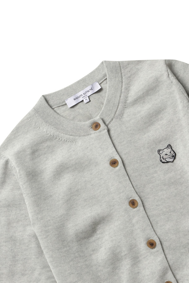 **BOLD FOX HEAD PATCH REGULAR CARDIGAN - LIGHT GREY MELANGE**는 울 소재의 남녀 공용 니트/스웨터 카디건입니다. 라이트 그레이 멜란지 컬러에, 라운드넥과 레귤러핏, 긴소매 기장으로 봄, 가을철에 착용하기 좋습니다. 가슴 부분 메종키츠네 자수 패치워크와 버튼 잠금, 네크라인, 허리, 커프스 부분의 리브 디테일이 특징입니다.
