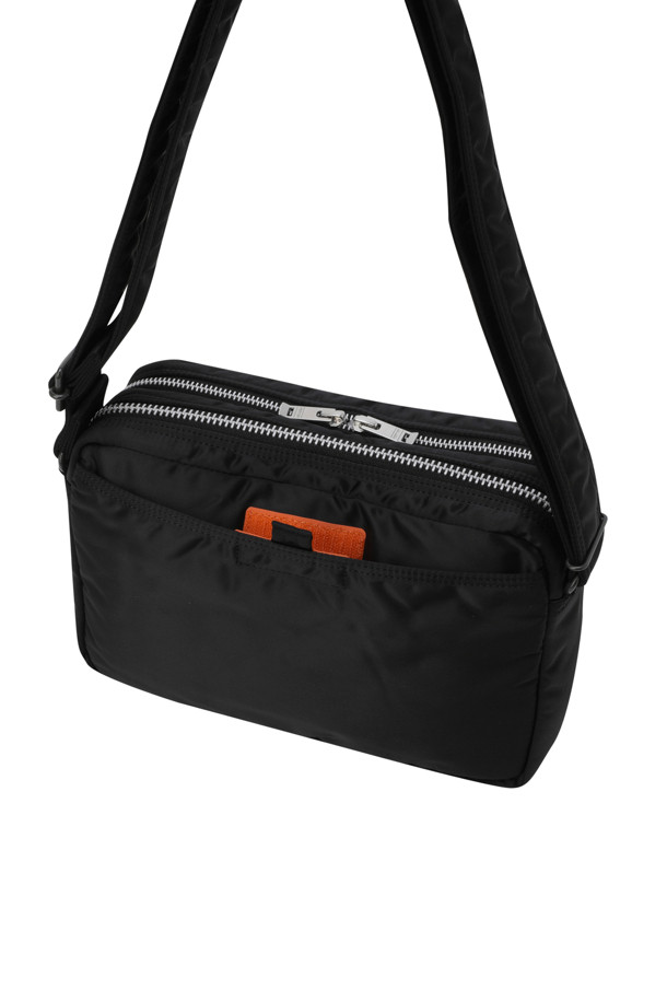 (PORTER) 탠커 슬링 백 W 지퍼 - 블랙은 미니멀하고 시크한 스타일을 추구하는 남성을 위한 슬링백입니다. 여행룩이나 비즈니스 캐주얼에 잘 어울리며, 사각 모양에 무지 패턴으로 디자인되어 깔끔한 느낌을 줍니다. 가볍고 내구성이 뛰어난 식물성 나일론 소재를 사용하여 일상과 여행에서 편안하게 사용할 수 있습니다. 지퍼형 잠금 방식과 뒷면 포켓으로 수납 기능을 더해 실용성을 높였으며, 미디엄 사이즈로 소지품을 효율적으로 보관할 수 있습니다.
