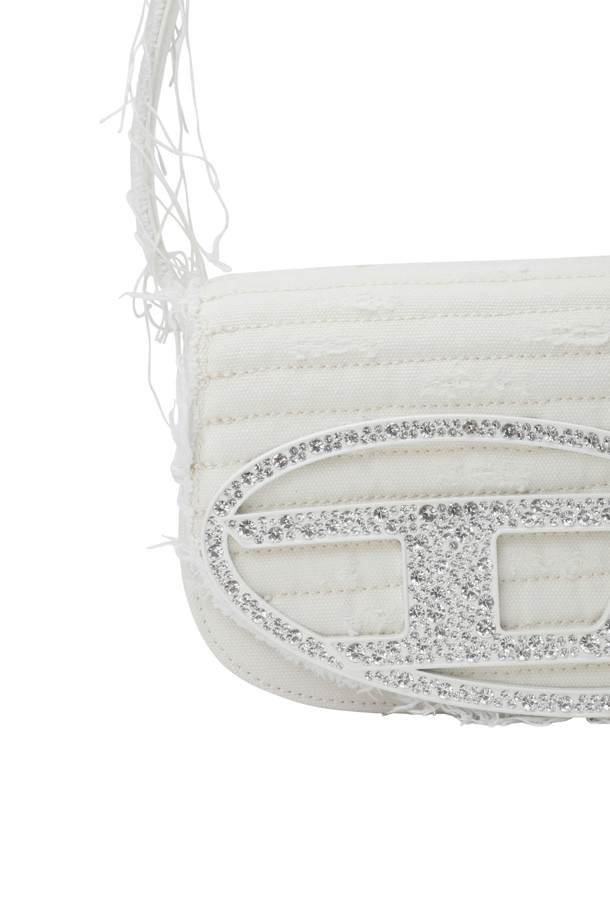 캔버스 소재와 가죽 트리밍의 조화가 돋보이는 1DR 아이코닉 숄더백입니다. 화이트 컬러에 퀼팅 패턴과 크리스탈, 로고 장식이 더해져 클래식하면서도 세련된 분위기를 연출합니다. 내부 슬립 포켓과 플랫 컴파트먼트가 있어 수납력을 높였으며, 크로스바디 스트랩으로 편안하게 착용할 수 있습니다.
