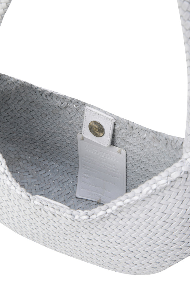 NOVA LUNA - 화이트 숄더백은 부드러운 버팔로 송아지 가죽 소재의 미디엄 사이즈 여성 가방입니다. 반원 형태의 무지 디자인으로, 우븐 핸들과 메달 참 장식이 돋보입니다. 핸드메이드 방식으로 제작되었으며, 안감이 없는 오픈 탑에 자석형 잠금 방식을 적용하여 실용성을 더했습니다. 루나 메짜의 컴팩트 버전으로, 둥글고 부드러운 디자인이 특징이며, 데이트룩, 쇼핑룩, 모임룩 등 다양한 TPO에 클래식, 미니멀, 시크 스타일을 연출하기 좋습니다.
