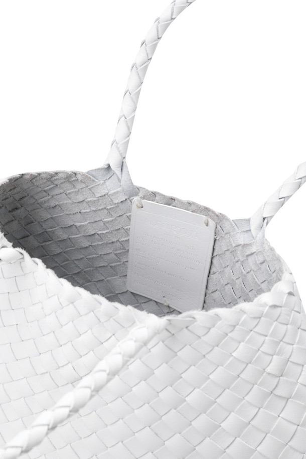 산타 크로체 스몰 - 화이트는 여성 고객을 위한 가방입니다. 가죽 소재의 화이트 컬러 토트백으로, 스몰 사이즈에 사각형 모양을 갖췄습니다. 핸드메이드 방식으로 제작되었으며, 불규칙한 가죽 직조 스트랩과 세인트 크리스토퍼 메달 참 장식이 돋보입니다. 오픈형 디자인으로, 데이트룩, 쇼핑룩, 카페룩 등 다양한 TPO에 클래식, 미니멀, 시크 스타일로 연출하기 좋습니다. 안감 처리는 되어 있지 않습니다.
