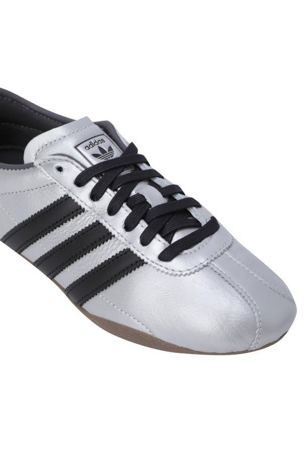 도쿄 - 실버 메탈릭 / 코어 블랙 / 검 여성 운동화는 일상, 산책룩, 여행룩에 모두 잘 어울리는 스니커즈입니다. 실버 메탈릭, 코어 블랙, 검정색의 세련된 색상 조합과 라운드 앞코 디자인이 특징입니다. 가죽 소재와 플랫 굽으로 편안함을 선사하며, 로우탑 디자인으로 다리가 길어 보이는 효과를 줍니다. 캐주얼, 미니멀, 클래식 스타일을 모두 소화할 수 있는 사계절 여성 운동화입니다. 고무 밑창으로 미끄럼 방지 기능도 갖추었습니다.
