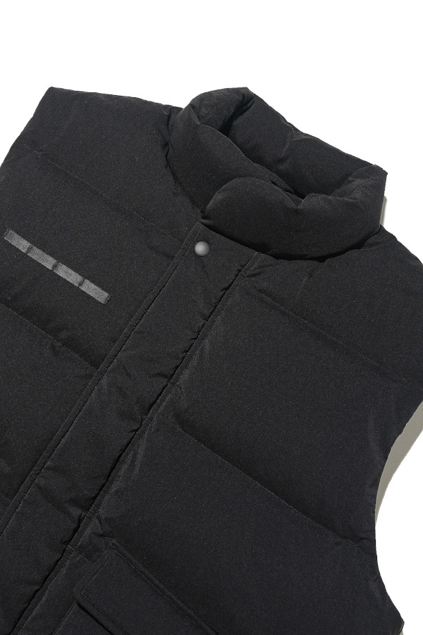 DUCK DOWN MARK 베스트 - 블랙은 겨울철 일상룩, 여행룩, 산책룩에 모두 잘 어울리는 아우터입니다. 영국군 바디 아머를 모티브로 한 밀리터리 스타일의 레귤러핏 베스트로, 유러피안 덕다운 충전재를 사용하여 뛰어난 보온성을 자랑합니다. 

두꺼운 두께감과 부드러운 촉감, 그리고 발수 기능까지 갖춰 한겨울에도 쾌적하게 착용할 수 있습니다. 블랙 컬러의 무지 디자인으로 클래식, 미니멀, 캐주얼 등 다양한 스타일링에 활용하기 좋으며, 레이어링이 용이하여 실용성을 더합니다. 
