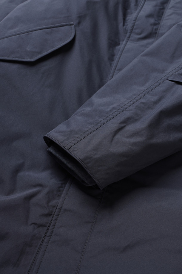 (NANAMICA) 고어텍스 롱 다운 코트 - 네이비는 겨울철 일상 및 아웃도어 활동에 적합한 남성용 다운 코트입니다. 방수, 투습, 발수 기능을 갖춘 고어텍스 소재와 폴리에스테르를 사용하여 우수한 기능성을 제공하며, 롱 기장과 넉넉한 레귤러 핏으로 편안한 착용감을 선사합니다. 미니멀한 디자인에 네이비 컬러, 무지 패턴으로 출근룩, 여행룩 등 다양한 스타일에 매치하기 용이합니다. 스냅 및 지퍼 여밈 방식, 리브 소매, 내부 포켓 디테일이 돋보이며, 두꺼운 두께감으로 보온성을 극대화한 파카 스타일의 아우터입니다.
