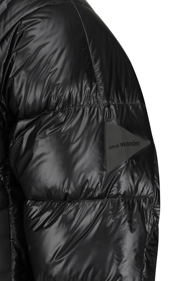 (AND WANDER) 다이아몬드 스티치 다운 후디 2 - 블랙은 아웃도어 활동과 일상에서 모두 활용 가능한 남녀 공용 다운 재킷입니다. 10데니어 PERTEX QUANTUM 소재와 헝가리산 화이트 구스 다운(93% 다운, 850 필파워)를 사용하여 뛰어난 보온성과 경량성을 제공합니다. 후드 기초 부분에는 보아 플리스 소재를 적용하여 부드러운 촉감을 더했으며, 다이아몬드 퀄팅 패턴과 미니멀한 디자인으로 스포티한 스타일을 연출합니다. 발수 기능과 밑단 드로우코드를 통해 변화무쌍한 날씨에도 쾌적하게 착용할 수 있으며, 여행, 등산, 캠핑 등 다양한 TPO에 활용 가능합니다.

