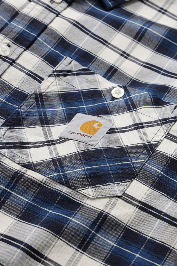 L/S TARBELL SHIRT - DARK NAVY / WHITE는 남성용 셔츠로, 다크 네이비와 화이트 컬러의 체크 패턴이 돋보이는 캐주얼 셔츠입니다. 옥스퍼드 코튼 소재를 사용하여 가을, 겨울에 적합하며, 루즈핏과 긴 소매 기장으로 편안한 착용감을 제공합니다. 앞면 버튼, 가슴 포켓, 지퍼 포켓 디테일과 직조된 스퀘어 라벨이 특징입니다.
