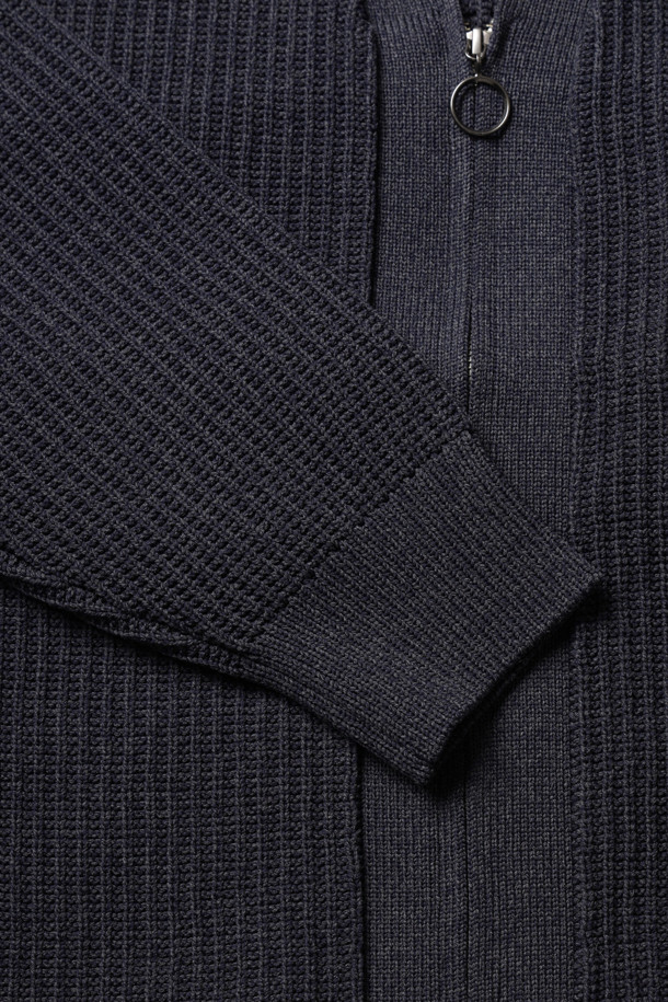 (NANAMICA) 5G 집업 가디건 - 다크 네이비는 미니멀하고 베이직한 스타일의 남성용 니트/스웨터입니다. 가을, 겨울 시즌에 어울리는 두꺼운 두께감과 긴 소매, 브이넥 디자인이 특징입니다. 100% 폴리에스테르 소재로 제작되어 일상복으로 편안하게 착용 가능하며, 출근룩, 비즈니스 캐주얼, 모임룩 등 다양한 TPO에 활용할 수 있습니다. 골지 패턴과 오버핏, 집업 여밈 방식은 스타일리시함을 더하며, 리사이클 소재 사용, 앞뒤 슬리브 구조, 어깨 가동성 향상, 옆선 포켓 등의 디테일이 돋보입니다. 다크 네이비 컬러로, 어떤 스타일에도 쉽게 매치할 수 있는 활용도 높은 아이템입니다.
