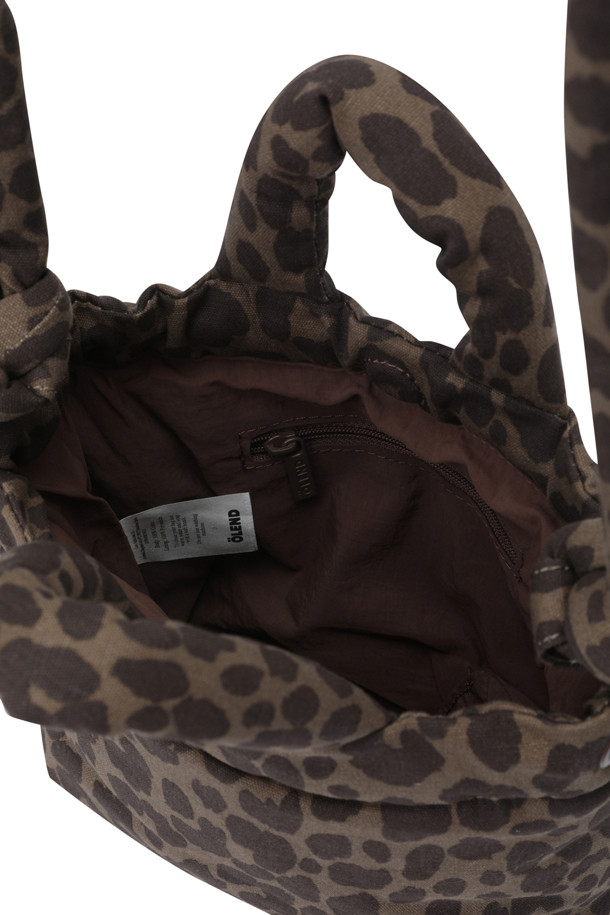 **MICRO ONA SOFT BAG - 레오파드**는 여성스러운 스타일을 완성하는 미니 사이즈 가방입니다. 부드러운 푹신함과 가벼운 착용감이 특징이며, 데이트룩, 쇼핑룩, 카페룩 등 다양한 TPO에 활용하기 좋습니다. 레오파드 패턴과 사각 디자인이 레트로, 캐주얼, 미니멀 스타일을 연출하며, 생활 방수 기능으로 실용성을 더했습니다. 스트랩은 최대 110cm까지 조절 가능하며, 내부 지퍼 포켓이 있어 수납도 용이합니다.
