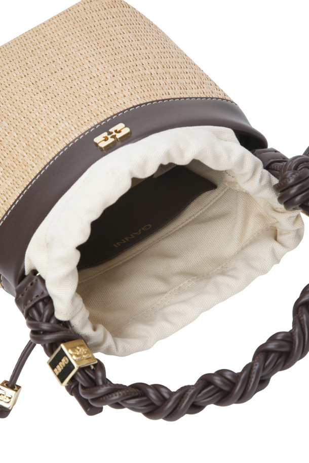 "Bou Bucket Bag - Tobacco Brown"은 라탄 소재의 스몰 사이즈 버킷백으로, 매듭 손잡이와 GANNI Butterfly 하드웨어 로고가 특징입니다. 캐주얼한 스타일에 끈 잠금 방식으로 디자인되었으며, 일상생활에서 편안하게 사용할 수 있습니다. 세련된 토바코 브라운 컬러는 어떤 스타일에도 잘 어울립니다.
