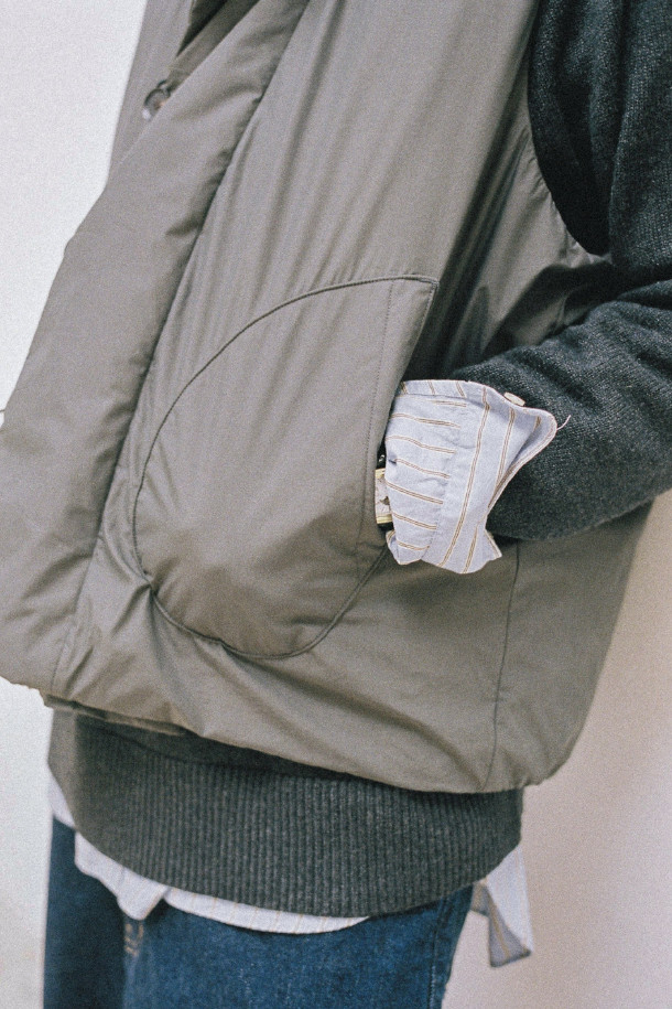 GOOSE DOWN MIL 베스트 - 차콜은 겨울철 캐주얼룩을 완성하는 데일리 아이템입니다. 밀리터리 무드를 담은 베이직한 디자인에, 무지 패턴과 차콜 컬러로 어떤 옷에도 쉽게 매치할 수 있습니다. 구스다운 충전재를 사용하여 보온성을 높였으며, 밑단 스트링 조절과 암홀 밴딩 디테일로 활동성을 더했습니다. 겉감은 면, 폴리에스테르, 나일론 혼방으로 부드러운 촉감을 자랑하며 생활 발수 기능까지 갖춰 실용적입니다. 산책이나 여행 시, 스타일리시하고 따뜻하게 착용할 수 있는 레귤러핏 베스트입니다.
