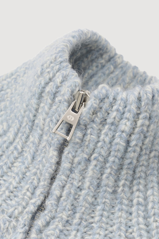 라이트 블루 컬러의 자수 포인트 집업 니트 가디건입니다. 래글런 소매와 하이넥 디자인으로 따뜻함과 스타일을 동시에 잡았습니다. 두꺼운 두께감의 니트 소재에, MULINE 타입 원사를 사용하여 포근한 착용감을 선사합니다. 등판 로고와 핸드메이드 자수 디테일이 유니크한 포인트를 더하며, 밑단 러플과 페플럼 디자인으로 여성스러운 실루엣을 연출합니다. 금속 지퍼로 간편하게 여밀 수 있으며, 가을, 겨울철 캐주얼 룩에 활용하기 좋습니다.
