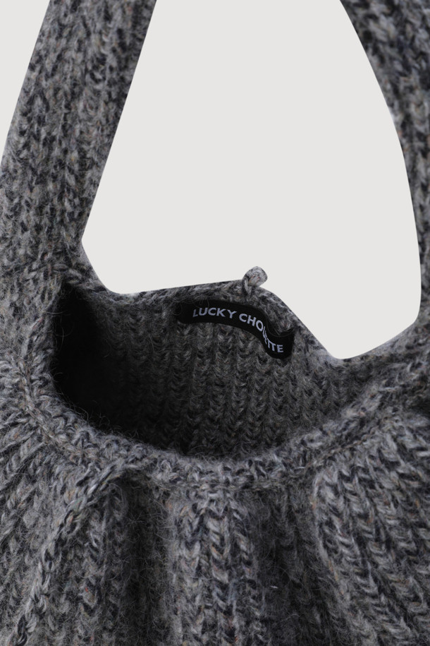 멜란지 그레이 컬러의 Frill Knit 숄더백(프릴 니트 숄더백)입니다. 부드러운 니트 소재에 볼드한 프릴 디테일이 더해져 유니크한 분위기를 연출합니다. 핸드메이드 방식으로 제작되었으며, 언발란스 디자인으로 세련된 멋을 더했습니다. 미니 사이즈로 데이트룩, 걸리시, 미니멀 스타일 연출에 적합하며, 끈 잠금 방식으로 편안하게 사용할 수 있습니다. MULINE 타입 원사를 사용하여 섬세하고 고급스러운 느낌을 줍니다.
