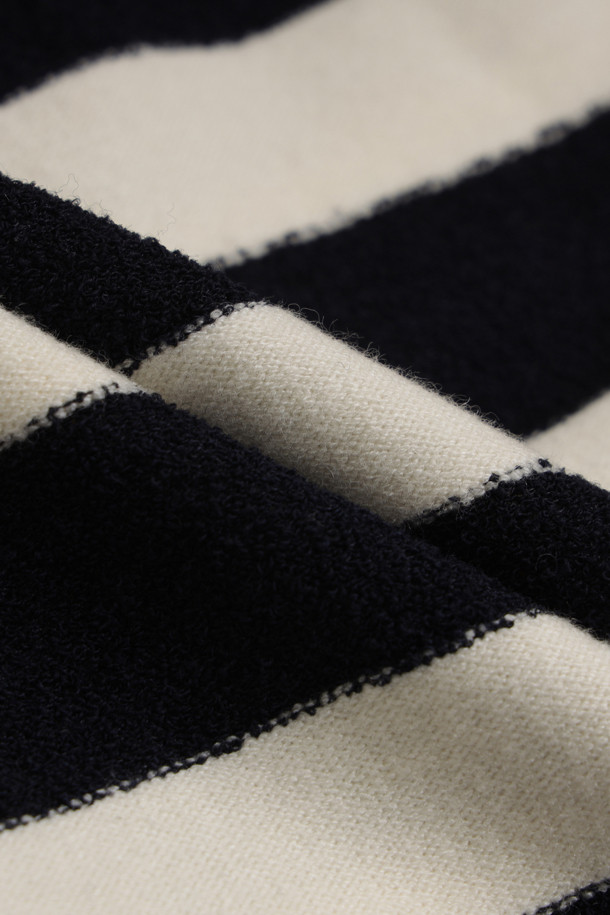 블랙과 화이트 스트라이프 패턴의 사이드 리본 니트 풀오버입니다. 부드러운 울 소재로 제작되어 가을, 겨울철 따뜻하게 착용 가능하며, 루즈핏과 라운드넥 디자인으로 편안한 착용감을 선사합니다. 양옆 트임과 립 조직 디테일, 사이드 리본으로 포인트를 더해 캐주얼하면서도 베이직한 스타일을 연출합니다. 긴 소매 기장과 두꺼운 두께감으로 겨울 데일리룩에 적합하며, 아울렛 전용 제품으로 만나보실 수 있습니다.
