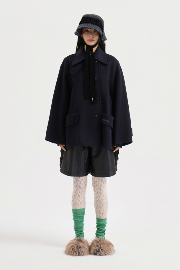 다크 네이비 컬러의 버클 칼라 하프 코트입니다. 캐시미어 10%와 울 소재를 혼방하여 부드러운 촉감을 선사하며, 가을과 겨울에 따뜻하게 착용할 수 있습니다. 힙을 덮는 하프 기장과 오버핏 디자인으로 편안하면서도 세련된 스타일을 연출해 줍니다. 버튼과 버클 여밈 방식, 빅 사이즈 아웃포켓 디테일이 돋보이며, 안감에는 LUCKY 로고 패턴이 적용되어 있습니다. 클래식, 캐주얼, 미니멀한 무드의 겨울 데일리룩, 오피스룩, 모임룩에 활용하기 좋습니다.
