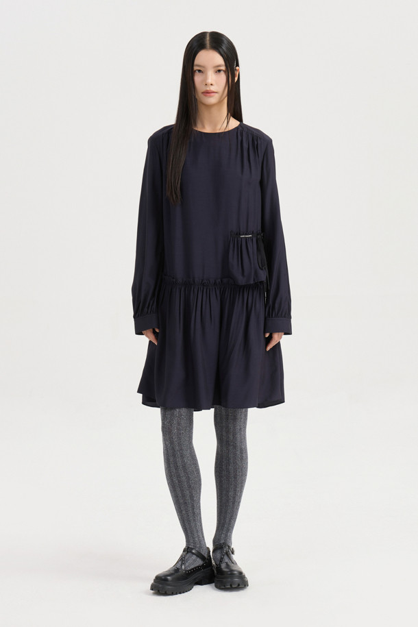 다크 네이비 컬러의 셔링 디테일 라운드넥 원피스입니다. 부드러운 레이온 소재로 제작되어 편안한 착용감을 선사하며, 루즈핏과 플레어 A라인 치마가 자연스러운 실루엣을 연출합니다. 허리선 아래 셔링으로 볼륨감을 더하고, 허리 부분 로고 테이프로 포인트를 주었습니다. 긴 소매와 뒷넥 단추 여밈으로 클래식하면서도 캐주얼한 분위기를 자아내 데이트룩, 모임룩, 또는 미니멀한 스타일을 연출하고 싶은 날에 적합합니다. 사계절 내내 활용 가능한 실용적인 아이템입니다.
