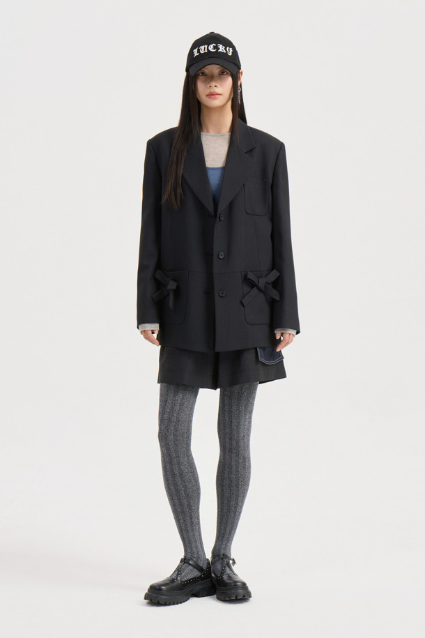 리본 디테일 폴리 싱글 재킷 (Ribbon Detail Poly Single Jacket, 블랙)은 클래식과 캐주얼 무드를 동시에 연출하는 여성 자켓입니다. 두껍고 뻣뻣한 폴리에스테르 소재로 제작되어 봄, 가을에 착용하기 좋으며, 중힙 기장의 박시 핏으로 편안한 착용감을 선사합니다. 싱글 버튼 여밈 방식에 리본 디테일 포켓이 더해져 포인트를 더하고, 안감에는 럭키 (LUCKY) 로고 패턴이, 소매 안감에는 스트라이프 패턴이 적용되어 있습니다. 소매는 레터링 테이프로 턴업하여 다양한 스타일을 연출할 수 있으며, 출근룩, 오피스룩, 모임룩 등 TPO에 맞춰 미니멀하고 세련된 스타일을 완성해보세요.
