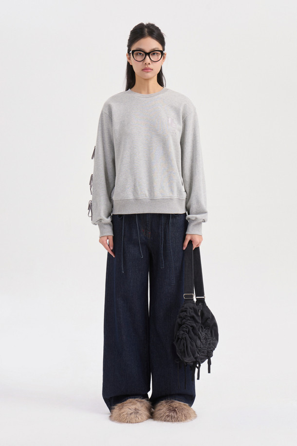 멜란지 그레이 컬러의 리본 포인트 맨투맨 티셔츠입니다. 캐주얼하고 미니멀한 스타일로, 봄, 가을에 어울리는 크롭 기장의 긴소매 디자인입니다. 오른쪽 소매에는 벨벳 리본 장식이, 가슴에는 슈에뜨 자수가 포인트로 자리 잡고 있습니다. 슬림핏으로 제작되어 더욱 세련된 핏을 연출하며, 일상에서 편안하게 착용할 수 있는 웨어러블 아이템입니다. 라운드넥으로 제작되어 어떤 스타일에도 잘 어울립니다.
