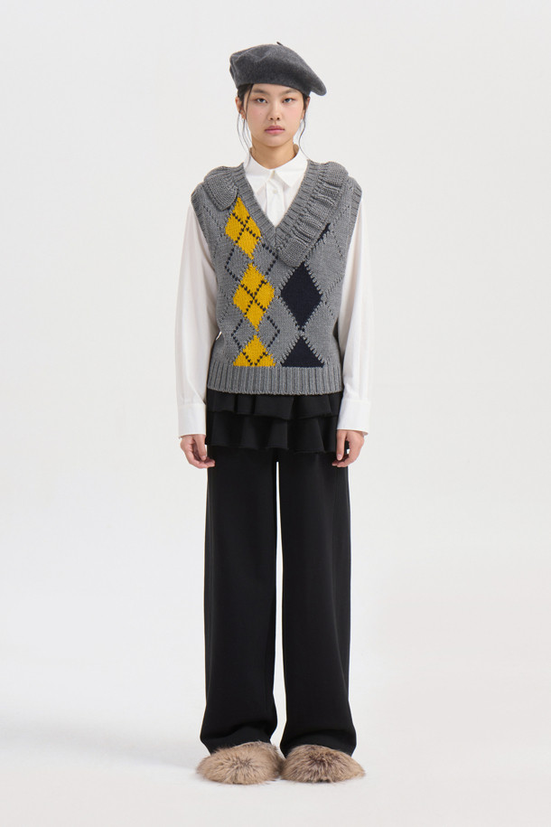 멜란지 그레이 컬러의 Argyle Frill Knit Vest (아르가일 프릴 니트 베스트)입니다. 여성용 니트 베스트로, 가을과 겨울에 따뜻하게 착용하기 좋습니다. 부드러운 울 소재에 아가일 패턴과 넥 라인의 프릴 디테일이 돋보이며, 스탠다드 핏으로 캐주얼, 클래식, 미니멀 스타일 모두 소화 가능합니다. 라운드넥과 민소매 디자인으로 다양한 레이어드 연출이 용이하며, 모임룩에도 활용할 수 있습니다. 중간 두께감으로 간절기부터 겨울까지 폭넓게 활용할 수 있는 아이템입니다.
